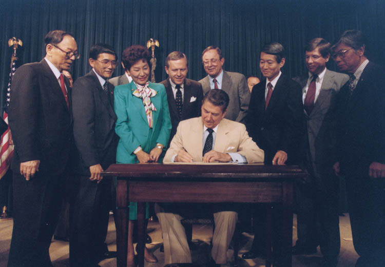 President Ronald Reagan signs the Civil Liberties Act of 1988 into law on August 10, 1988